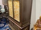 a wooden cabinet with a buddha statue on top of it
