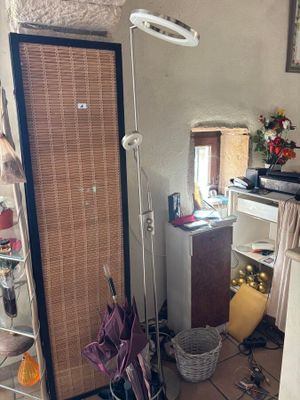 a room with a door, a mirror, a shelf, and a lamp