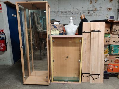 a wooden cabinet with a glass door and a vase on top