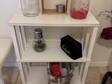 a white shelf with jars on it in a room
