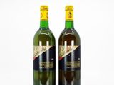 deux bouteilles de vin posées l'une à côté de l'autre sur une surface blanche
