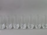 a lot of glasses that are lined up on the table