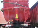 un gros camion rouge garé à côté d'un train