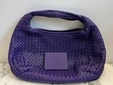the purple purse is sitting on a marble counter top