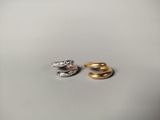 two gold and silver rings sitting next to each other on a white surface