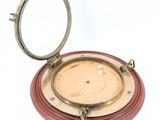une plaque en bois et en laiton surmontée d'un miroir