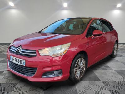 a red citrole is parked in a room with a checkered floor
