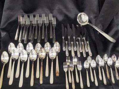 a lot of spoons and forks laid out on a table