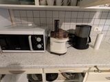 un micro-ondes et un mixeur posés sur un plan de travail dans une cuisine