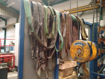 beaucoup de ceintures accrochées à un porte-vêtements dans un garage