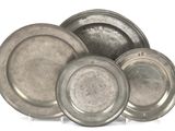 a lot of silver plates sitting on a white surface