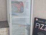 a pizza shop sign next to a pizza fridge