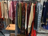 a rack of clothes in a clothing store with clothes hanging on it