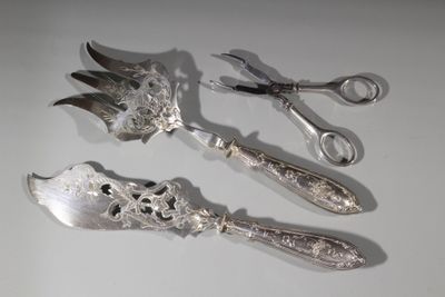 trois cuillères en argent et une paire de ciseaux posés sur une table