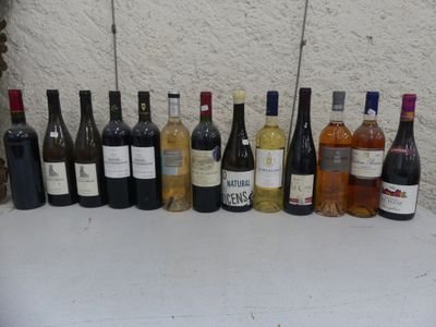 des bouteilles de vin alignées sur une table devant un mur blanc
