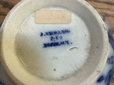 a blue and white cup on a table with a sticker on it