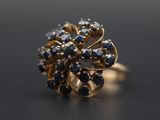 un gros plan d'une bague en or sertie de pierres bleues