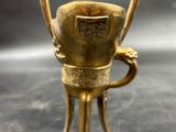 brass figurine of a cup with two legs and a handle