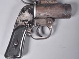 un petit pistolet posé sur une surface blanche