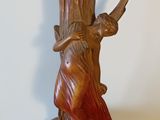 a statue of a woman holding a vase on a table