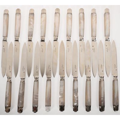 un ensemble de huit couteaux à manche en bois posés sur un fond blanc