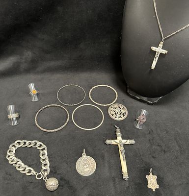 a lot of silver jewelry on a black cloth