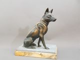 statue en bronze représentant un chien assis sur un socle en marbre