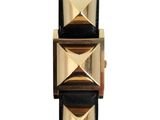 the watch is made of black leather with gold pyramids on it