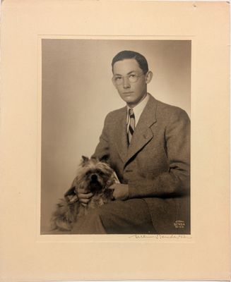 portrait d'un homme en costume avec un chien sur les genoux