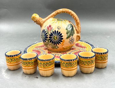un service à thé composé de tasses et d'une théière, posé sur un plateau