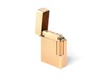un briquet doré posé sur une surface blanche