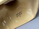 a close up of a vase with a bird on it ' s head