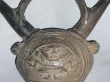 a small vase that has a handle on top of it