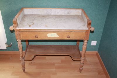 a wooden table with a marble top in the corner of a room