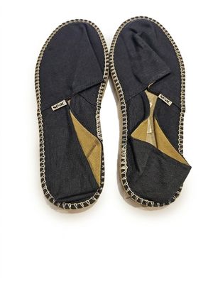 une paire de pantoufles noires et dorées sur fond blanc