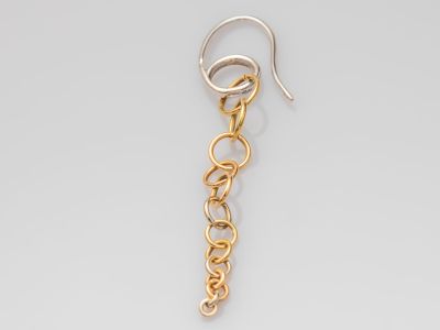 gros plan d'une paire de boucles d'oreilles sur une surface blanche