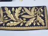 a black and gold purse with a gold leaf design on it