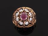 a close up of a gold ring with a ruby and diamond center