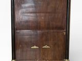 une vieille commode en bois surmontée d'une horloge