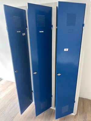 trois casiers bleus dans une pièce au sol en parquet