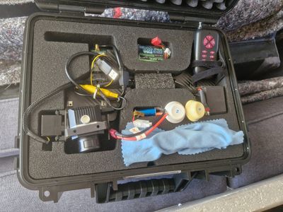 a black case with tools in it sitting on a couch