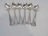 six spoons are lined up in a row on a white surface