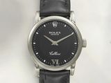 un gros plan d'une montre noire dont le cadran est orné de chiffres romains