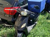 une voiture garée à côté d'un scooter dans l'herbe