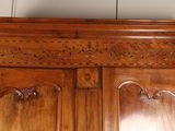 a wooden armoire with carvings on the top of it