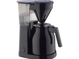 La cafetière noire est posée sur un plan de travail blanc