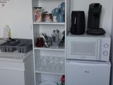 une petite cuisine équipée d'un micro-ondes, d'un réfrigérateur et d'un lave-vaisselle