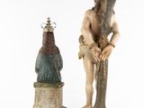 two statues of a man with a crown on his head and a bird on his shoulder