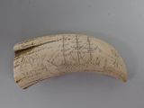 an elephant ' s tusk with a drawing of ships on it