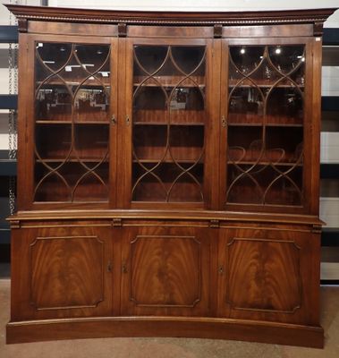 a large wooden china cabinet with glass doors and shelves